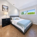 Belffin-Gray-upholstered-bed-frame-with-white-and-light-blue-bedding-black-nightstand-and-large-bright-window