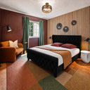 Belffin-Black-upholstered-bed-frame-with-tufted-headboard-white-and-brown-bedding-wooden-slat-wall-and-brown-armchair